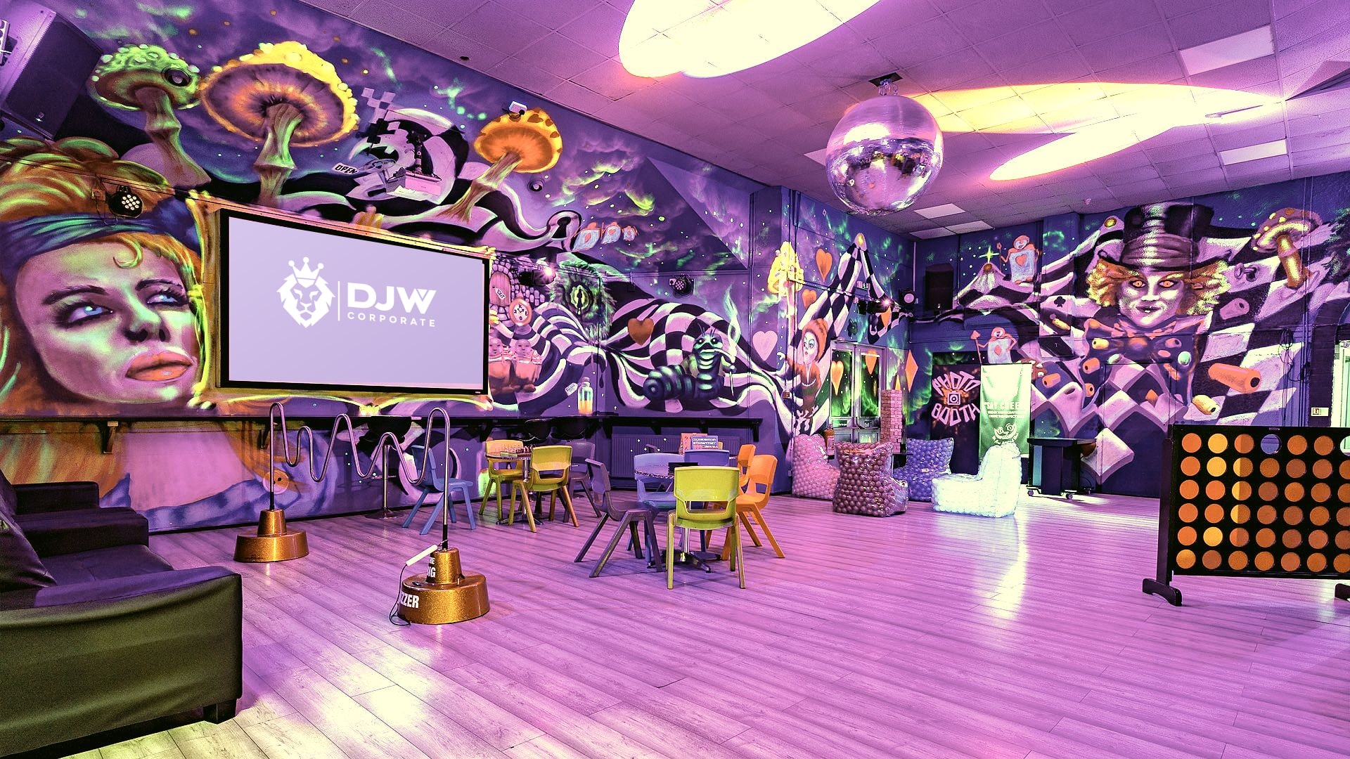 The main hall under its lights, with the screen, the murals and the mirror ball
